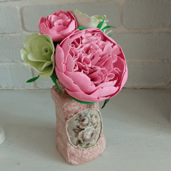 Delicate composition of pink peonies and eustomes in a handmade vases