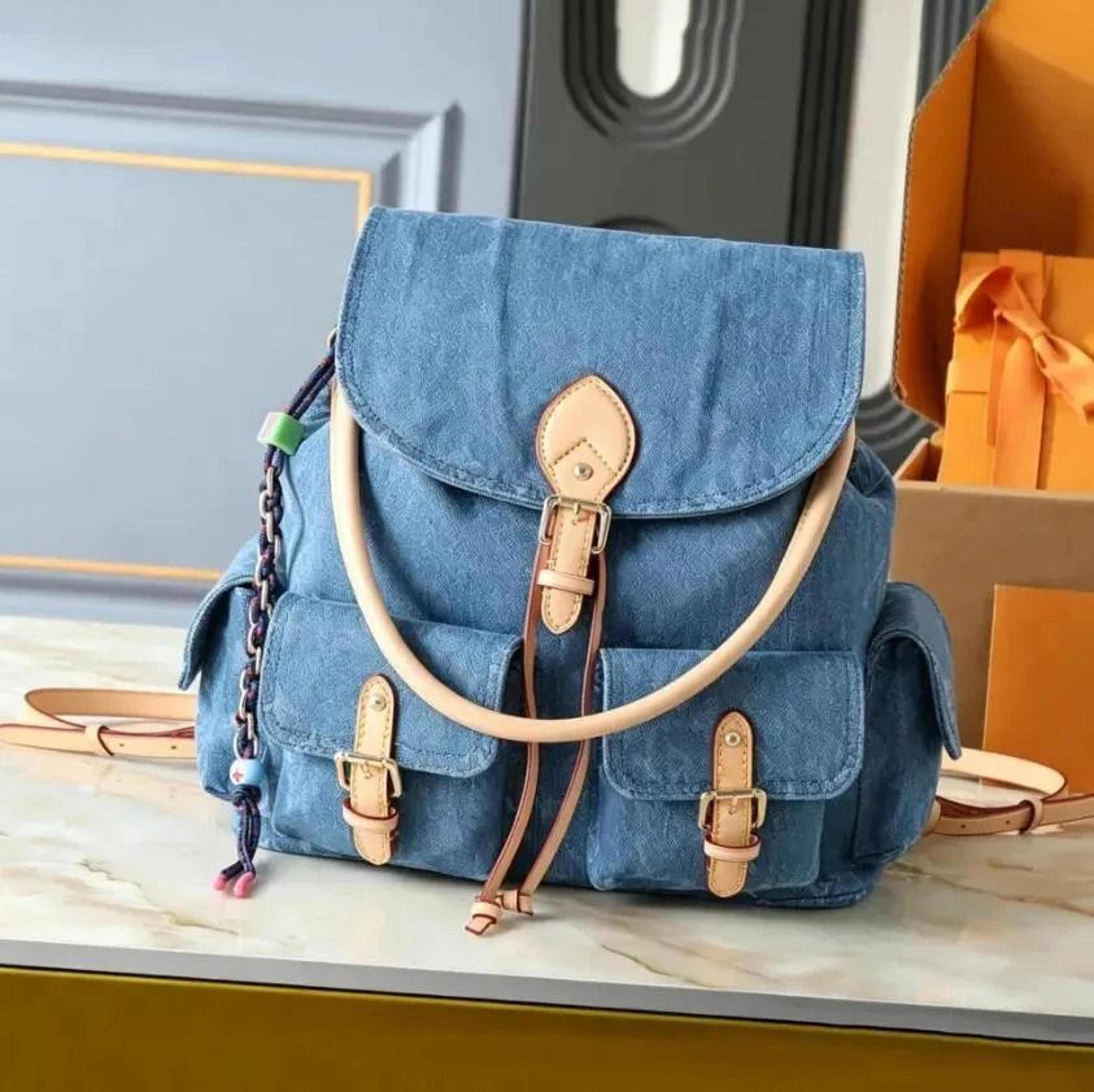 womens denim backpack with zipper closure tassel detail and interior phone pocket