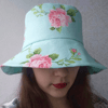 Summer hat bucket made of cotton in flowers. Beach sun hat for women. Fashion designer hat in roses. Cute elegant hat.