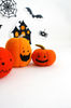 Felt orange Halloween pumpkins standing in the background of painted Halloween decorations, close-up view