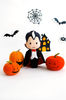 Felt toys - vampire Count Dracula and orange Halloween pumpkins standing in the background of painted Halloween decorations, front view