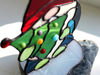 Christmas-tree-made-of-green-glass-and-glued-to-it-Christmas-balls-made-of-glass-drops-of-different-colors-Enlarged-fragment-of-a-stained-glass-suncatcher-gnome
