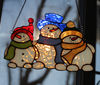 Christmas-stained-glass-suncatcher-family-of-snowmen-hanging-on-window-The-white-glass-of-which-the-snowmen's-bodies-are-made-has-an-unusual-effect-and-shines-w