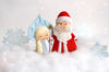 Felt toys Snow maiden and grandfather Frost against the background of snowflakes