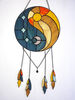 Round stained glass dreamcatcher with blue and yellow Yin Yang symbol with hanging chains is lying on a white background.jpg
