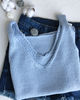 folded knitted t-shirt in blue lies on jeans.JPG