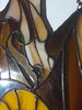 Stained glass depicting a brown dragons head and part of the wing with solder covered in black patina.jpg
