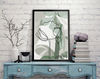 Three floral posters in green tones hang on the wall