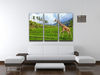 The giraffe goes on a green grass against mountains 3 Split Panel Canvas Print