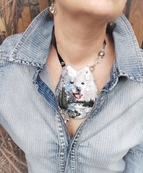 Pendant or brooch embroidered the head of a husky on the background of a landsca