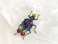 Embroidered brooch beetle Night iris. Beetle with flower and glass