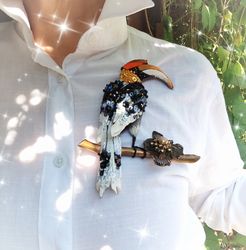 Large brooch with an embroidered hornbill.  On a dried branch with a metallic vintage flower