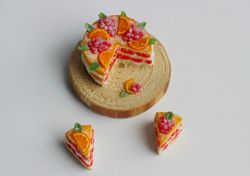 Miniature food for dollhouse, naked cake with oranges and berries with two cut-off pieces at 1:12 scale