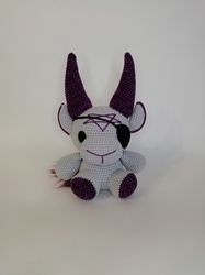 Gray crochet baphomet plush with dark purple horns in the view of a pirate - gothic gift for horror lovers