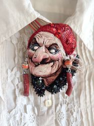 Embroidery brooch-pendant with a portrait of a witch, Baba Yaga. It's called "205 - I'm the highlight again!"