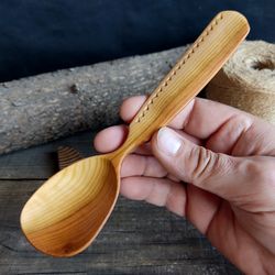 Handmade wooden spoon from natural apricot wood with decorated handle for eating or serving