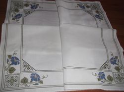 Embroidered tablecloth on the table. Cross stitch. Embroidered tablecloth in flowers.