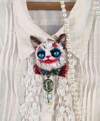 Embroidered brooch of the Joker Cat with a tie made of natural and vintage beads.
