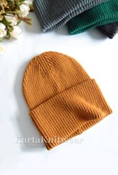 Knitted hat made of merino wool in mustard orange color