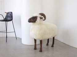 Big life-size Ram lamb chair in Lalanne style. Interior statue animal.Sheepskin stool minimalist decor or wabi sabi. Art