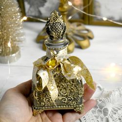 gold glass bottle for storing perfumes and aroma oils with a voluminous decor