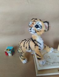 Tiger cub is a soft knitted toy. Cute toy amigurumi tiger. This tiger is a souvenir doll
