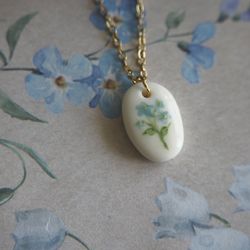 Polymer clay necklace with forget me not drawing