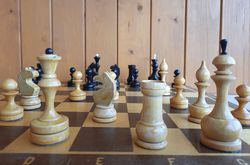 Space on the chessboard: small wooden Soviet chess pieces & middle-sized folding chess board