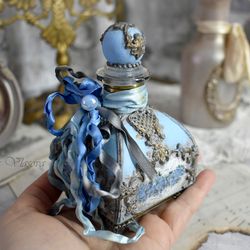 blue glass bottle for storing perfumes and aroma oils with a voluminous decor