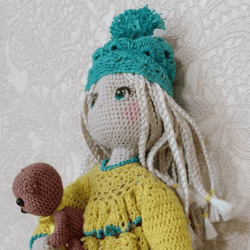 Knitted doll in a yellow dress, with a teddy bear