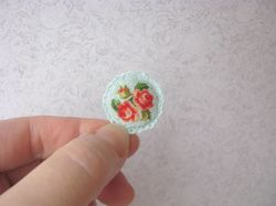 Embroidery kit for a miniature sofa cushion for a dollhouse in 1/12 scale. Small roses on turquoise