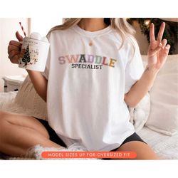 Swaddle Specialist Shirt, Mother Baby Nurse Shirt, Labor and Delivery Nurse Sweater, Gift for Nurse Week, Postpartum Nur
