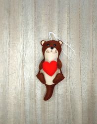 Felt otter. Otter with a red heart. Otter toy. New Year's decor otter. New Year's ornament otter