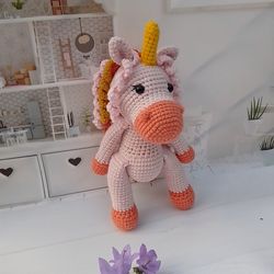 Crochet unicorn. Crochet animal.The unicorn is bright, yellow, blue, blue