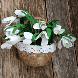 A bouquet of delicate handmade snowdrops in a basket.