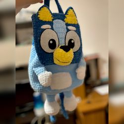 Handmade crochet backpack in the shape of a bluey dog, perfect for adults and kids. A unique and adorable gift.