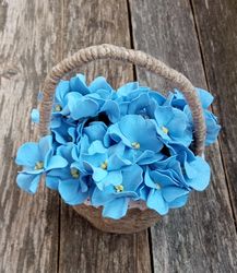 Delicate composition blue violets in linen basket. Everything from the flower stamens to the basket is made by hand.
