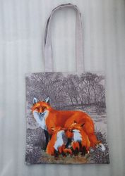 Reusable brown tote bag made of eco-friendly cotton canvas, with a drawing of a fox and small foxes