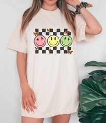 checkered pattern smiley face shirt, retro smile shirt, trendy smile face shirt, happy face graphic, butterfly  smiley s