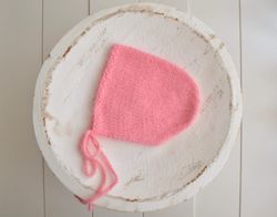 Newborn girl knitted salmon bonnet photo prop . Coral colour angora bonnet for new baby girl first photo shoot. Fuzzy ne