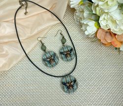 Author's set of handmade jewelry.Earrings and pendant on a cord with voluminous flies.