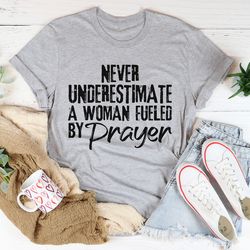 never underestimate a woman fueled by prayer tee