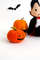 Felt orange Halloween pumpkins standing near the vampire Count Dracula in the background of painted Halloween decorations