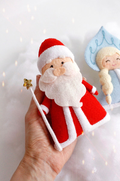 Felt grandfather Frost and Snow maiden toys against the background of snow