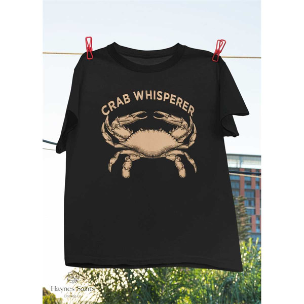 https://www.inspireuplift.com/resizer/?image=https://cdn.inspireuplift.com/uploads/images/seller_products/1684375808_MR-18520239944-crab-whisperer-vintage-t-shirt-crabbing-hunting-fishing-crabs-image-1.jpg&width=600&height=600&quality=90&format=auto&fit=pad