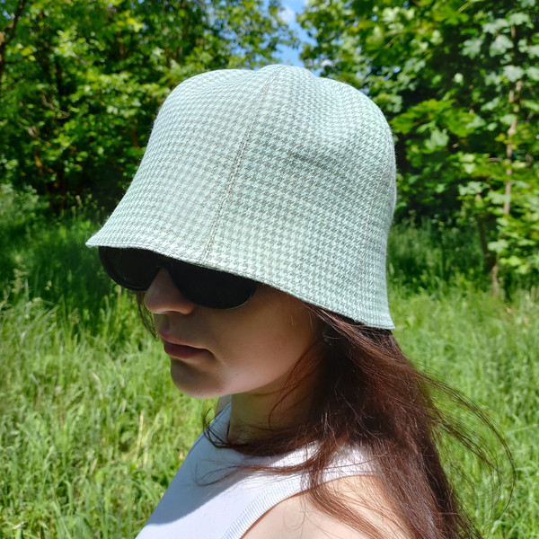 A bell hat made of linen fabric with a houndstooth print. Panama hat with a pied-de-poule print. Mint panama hat  tulip.