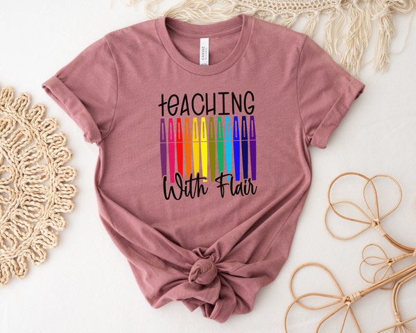 https://www.inspireuplift.com/resizer/?image=https://cdn.inspireuplift.com/uploads/images/seller_products/1688134543_TeachingWithFlairFlairPensTeacherShirtTeacherTeeTeachShirtTeacherT-ShirtsTeacherGiftFunnyTeacherShirtsFlairPenTee-7.jpg&width=600&height=600&quality=90&format=auto&fit=pad
