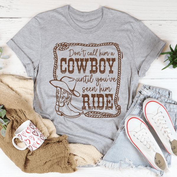Don't Call Him A Cowboy Until You've Seen Him Ride Tee.png