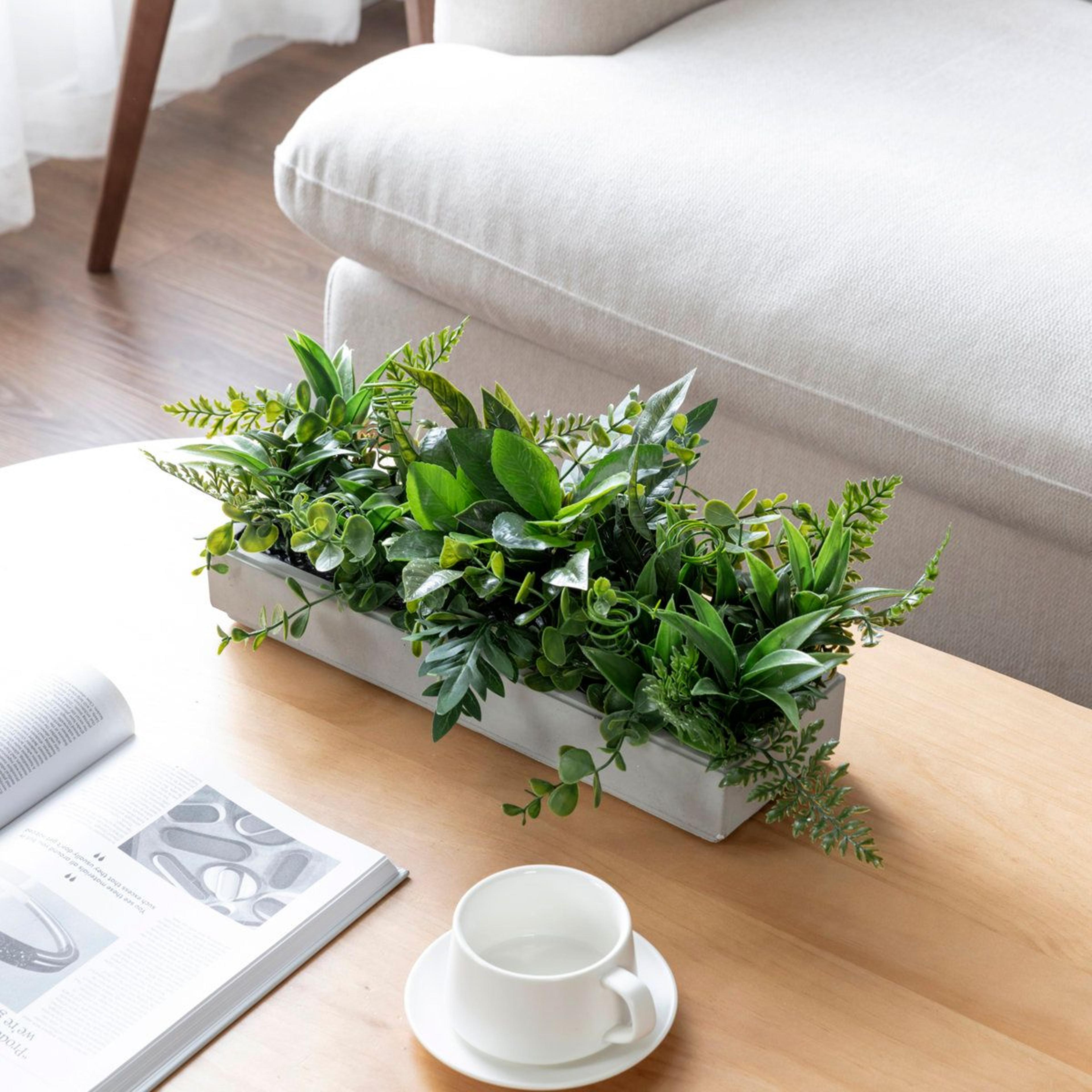 lifelike faux greenery centerpiece in cement planter