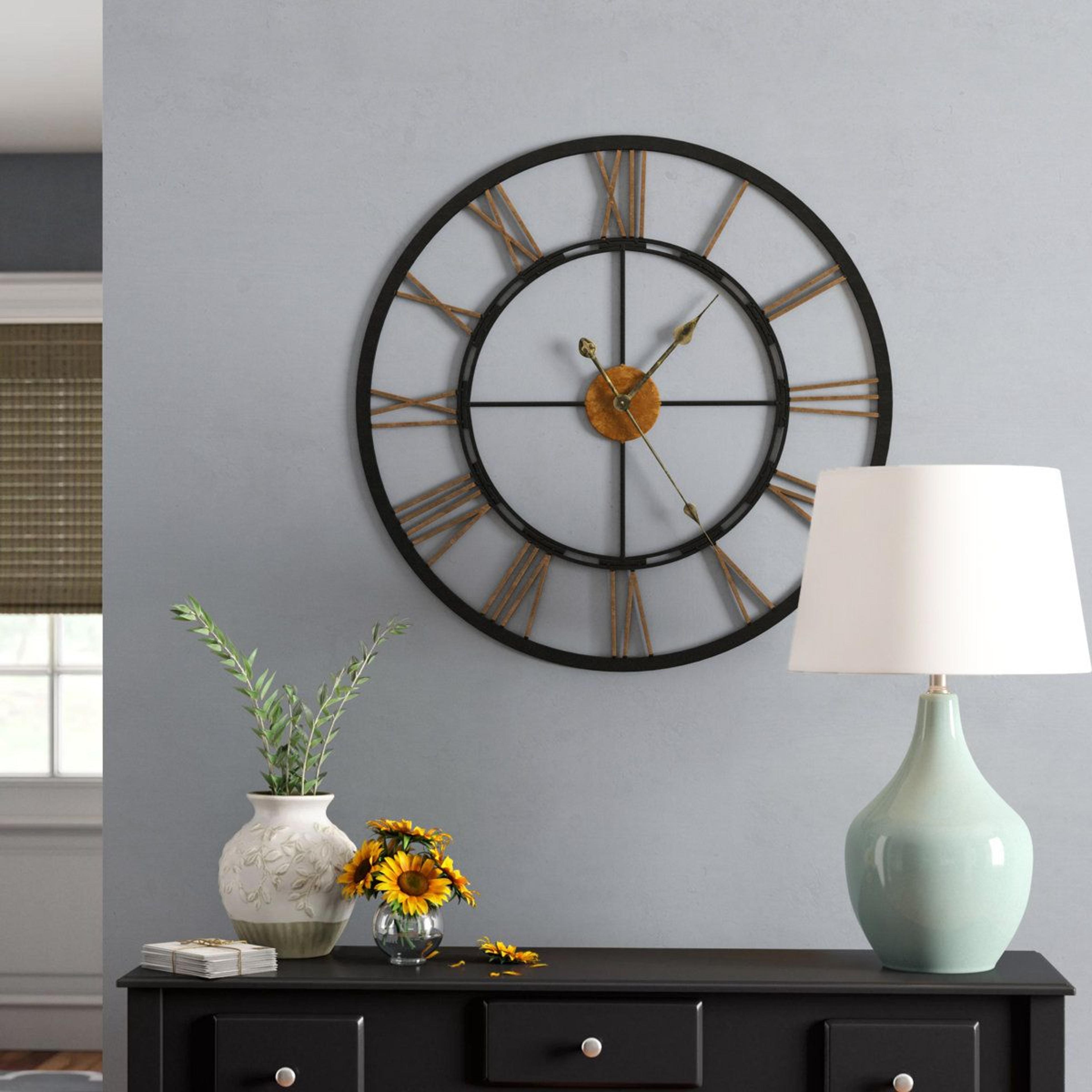 oversized metal wall clock with gold roman numerals